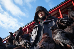 a man in a black hoodie with many birds