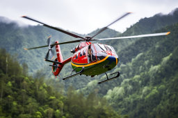 un hélicoptère survolant une forêt