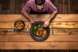 Un uomo seduto a un tavolo con una ciotola di cibo