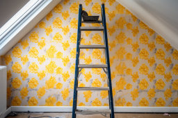 une échelle dans une pièce avec du papier peint jaune