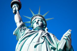 Une statue de la liberté avec une torche avec Statue de la Liberté en arrière-plan