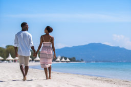 Egy férfi és nő, aki kezét tart egy tengerparton