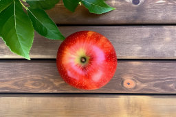 a red apple on a wooden surface