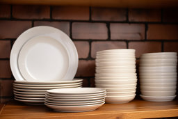 Stacked White Dishes on Wooden Shelf