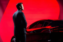 a man in a suit standing next to a car