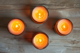 Four Lit Candles on Wooden Surface