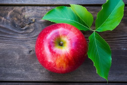 Fresh Apple with Green Leaves on Wooden Surface